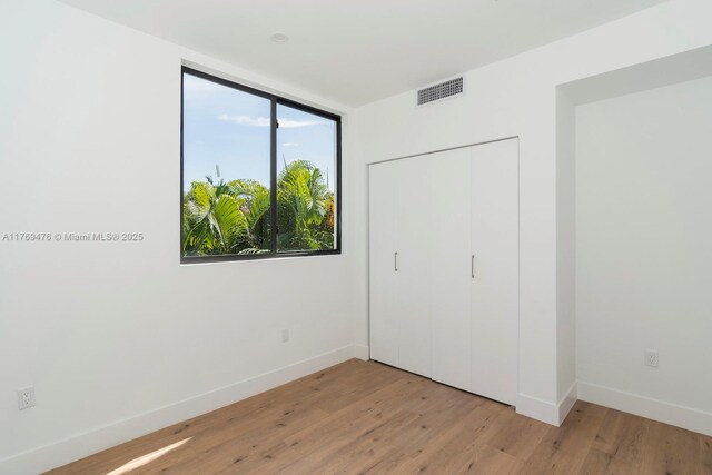 1635 E Broward Blvd, Fort Lauderdale, FL 33301 - unfurnished bedroom with light wood-style floors, baseboards, and a closet