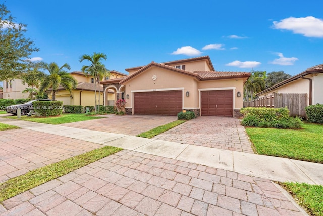 3626 SE 1st St, Homestead, FL 33033 - mediterranean / spanish-style home featuring fence, stone siding, decorative driveway, stucco siding, and a garage