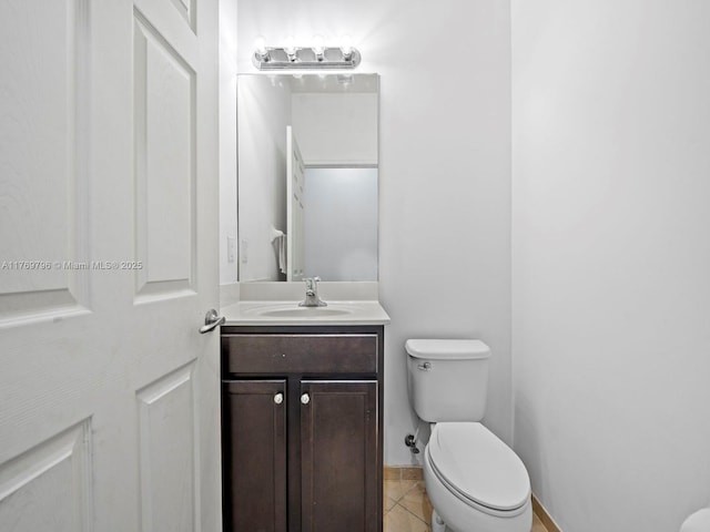 half bath with vanity, toilet, and tile patterned flooring