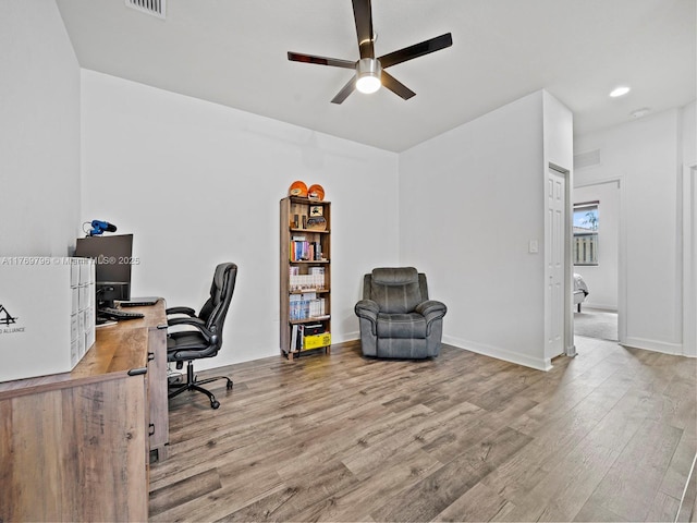 office space with a ceiling fan, visible vents, and wood finished floors