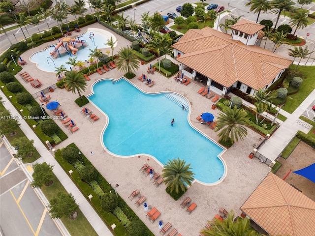 community pool featuring a water slide, a water play area, and a gazebo
