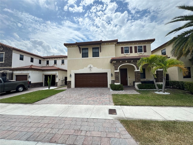 9840 NW 86th Ter, Doral, FL 33178 - mediterranean / spanish-style home with decorative driveway, a garage, a front yard, a tile roof, and stucco siding