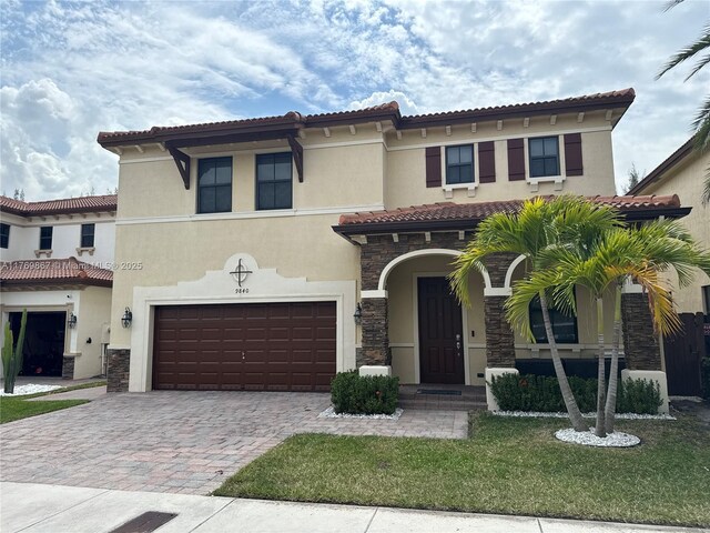 9840 NW 86th Ter, Doral, FL 33178 - mediterranean / spanish home with a tile roof, driveway, stone siding, stucco siding, and an attached garage