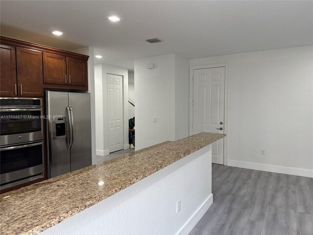9840 NW 86th Ter, Doral, FL 33178 - kitchen with light stone countertops, wood finished floors, stainless steel appliances, visible vents, and recessed lighting