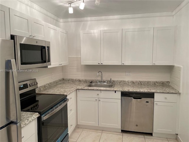 kitchen with crown molding, a sink, white cabinetry, light tile patterned floors, and stainless steel appliances