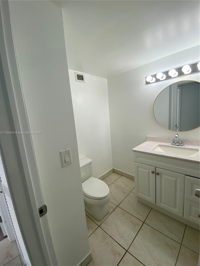 half bath with tile patterned flooring, vanity, toilet, baseboards, and visible vents