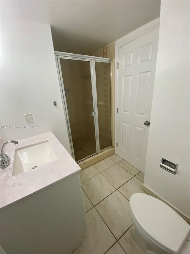 full bathroom featuring a stall shower, tile patterned floors, toilet, and vanity
