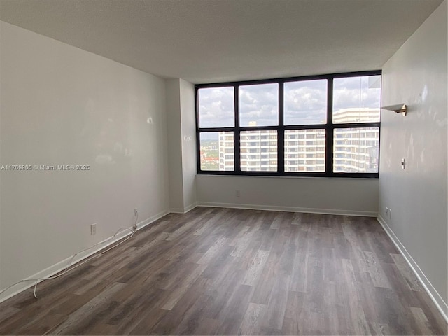 empty room featuring baseboards and wood finished floors