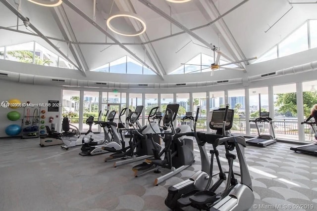 exercise room featuring visible vents, high vaulted ceiling, and a wealth of natural light