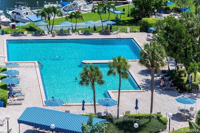 community pool with fence and a patio area