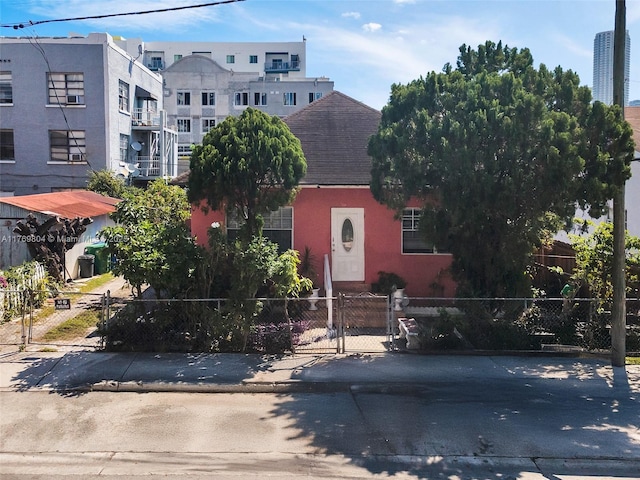 view of front of property with a fenced front yard and roof with shingles