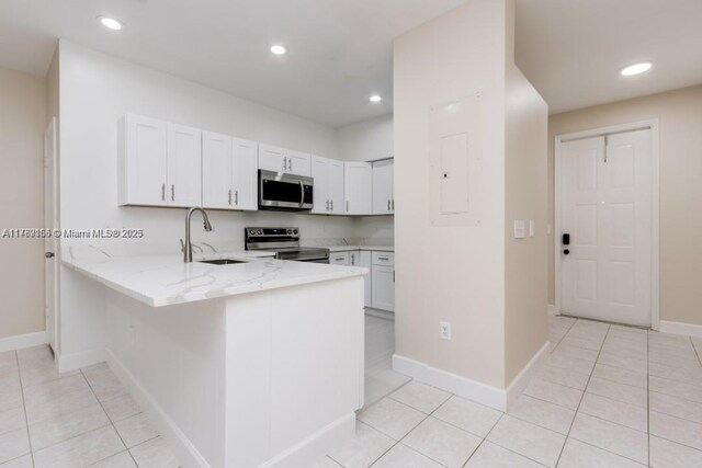 4834 NW 58th Mnr, Coconut Creek, FL 33073 - kitchen featuring electric panel, a peninsula, stainless steel appliances, a sink, and light stone counters