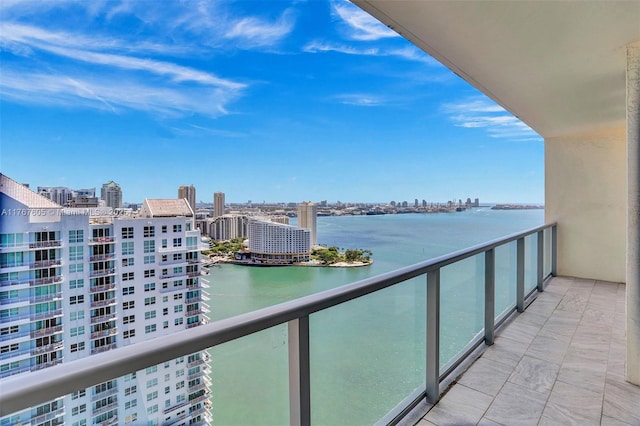 balcony with a water view and a view of city