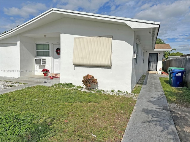 1167 NE 111th St, Miami, FL 33161 - view of home's exterior featuring stucco siding, fence, cooling unit, and a yard