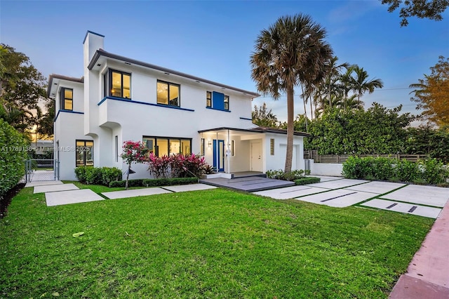 6166 Pine Tree Dr, Miami Beach, FL 33140 - contemporary home with a gate, stucco siding, and a chimney
