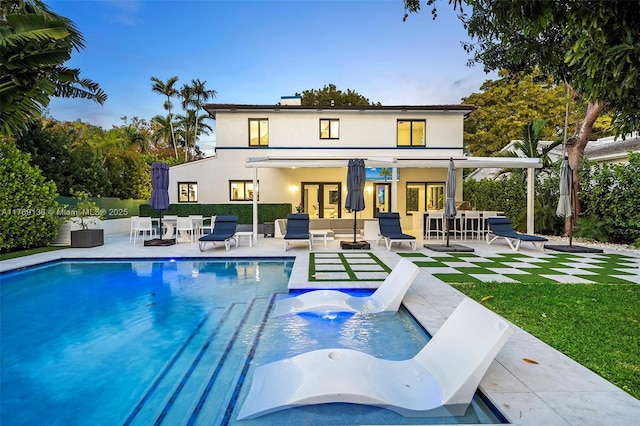 outdoor pool with a patio area and a lawn