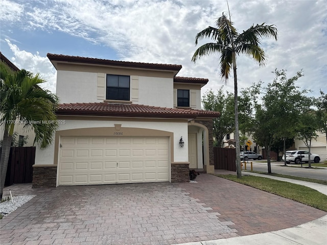10086 NW 89th Ter, Doral, FL 33178 - mediterranean / spanish-style home with a tile roof, stucco siding, stone siding, decorative driveway, and a garage