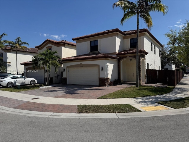 10086 NW 89th Ter, Doral, FL 33178 - mediterranean / spanish-style house with fence, a tiled roof, decorative driveway, a garage, and stucco siding