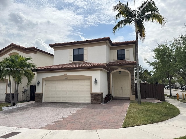 10086 NW 89th Ter, Doral, FL 33178 - mediterranean / spanish home with a tile roof, stone siding, stucco siding, decorative driveway, and a garage