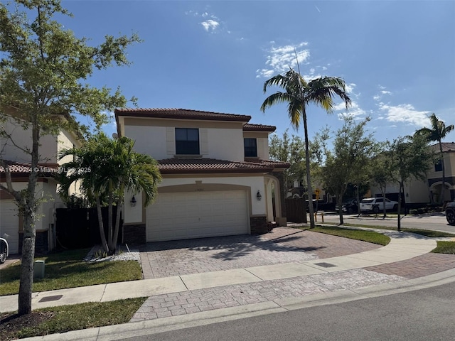 10086 NW 89th Ter, Doral, FL 33178 - mediterranean / spanish home featuring a tile roof, stone siding, stucco siding, decorative driveway, and a garage
