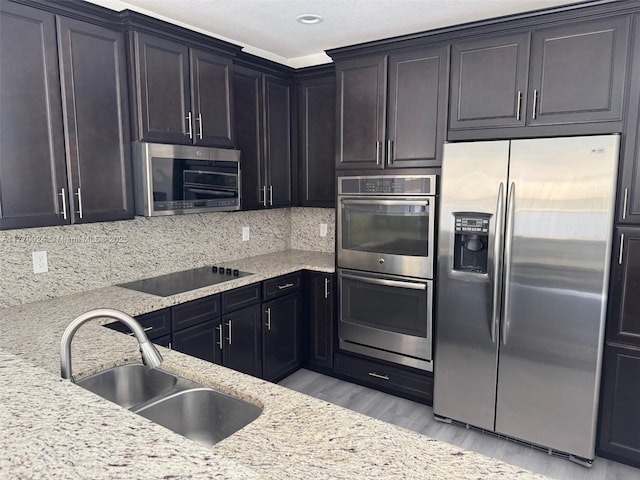 10086 NW 89th Ter, Doral, FL 33178 - kitchen with light stone counters, a sink, tasteful backsplash, appliances with stainless steel finishes, and light wood-style flooring