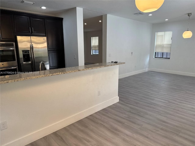 10086 NW 89th Ter, Doral, FL 33178 - kitchen featuring recessed lighting, stainless steel appliances, light wood-style floors, and light stone counters