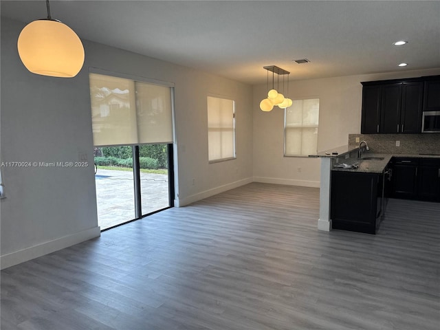 10086 NW 89th Ter, Doral, FL 33178 - kitchen featuring stainless steel microwave, backsplash, a sink, dark cabinets, and wood finished floors