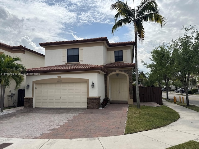 10086 NW 89th Ter, Doral, FL 33178 - mediterranean / spanish house featuring stone siding, a tile roof, stucco siding, and decorative driveway