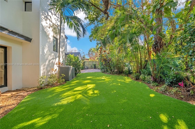 view of yard featuring cooling unit and fence