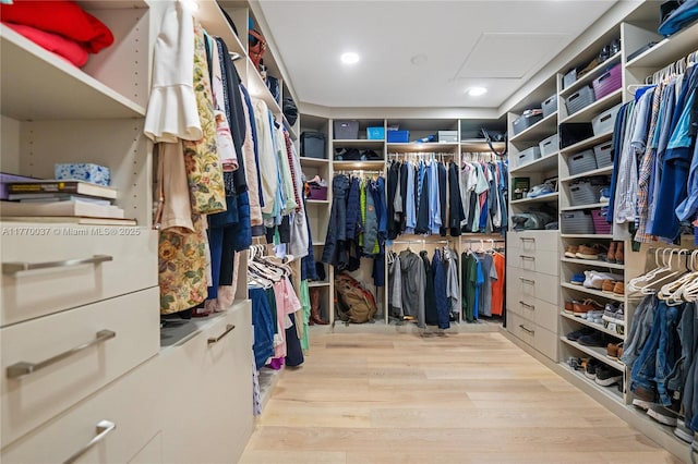 walk in closet featuring attic access and wood finished floors