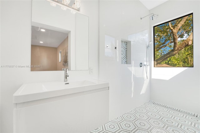 full bath featuring tiled shower and vanity