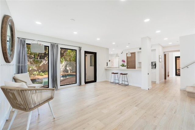 unfurnished living room with baseboards, light wood-type flooring, and recessed lighting