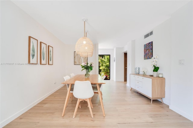 dining space with baseboards, visible vents, and light wood-style floors