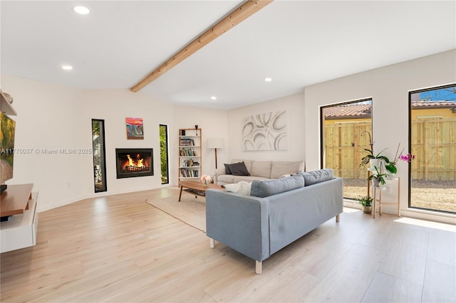 living room featuring light wood finished floors, recessed lighting, and a glass covered fireplace