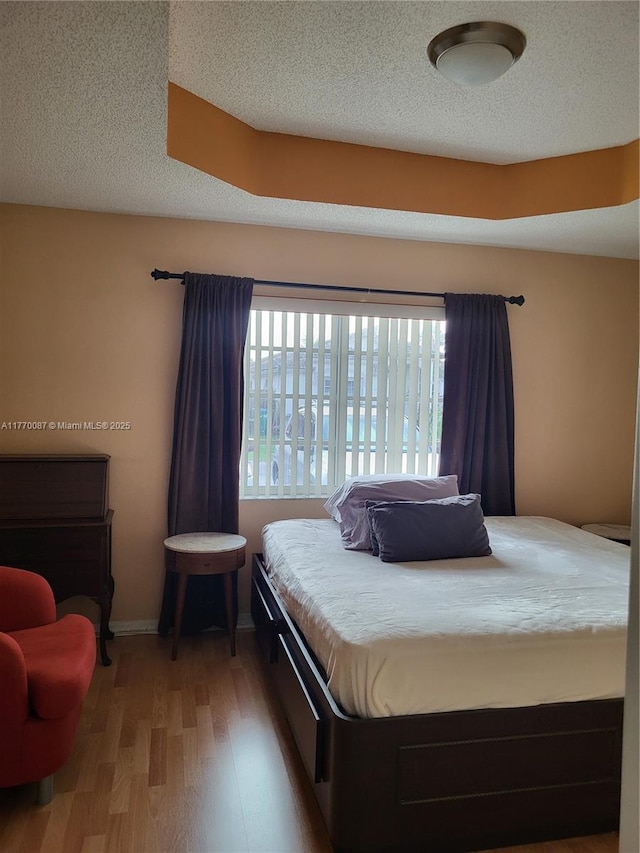 14144 SW 149th Pl, Miami, FL 33196 - bedroom with a textured ceiling, baseboards, and wood finished floors