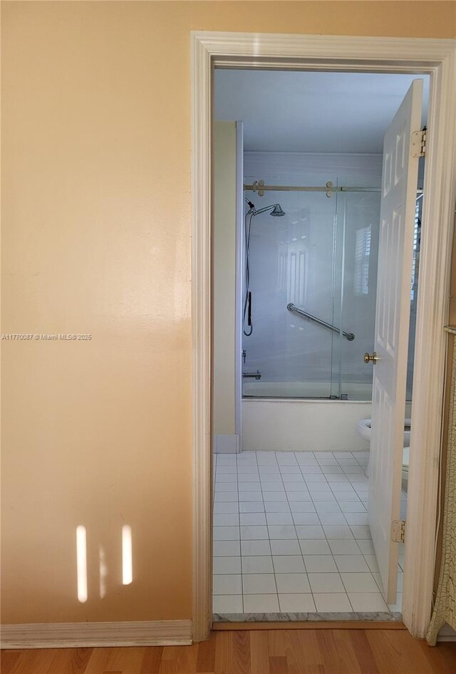 14144 SW 149th Pl, Miami, FL 33196 - full bathroom featuring toilet, wood finished floors, enclosed tub / shower combo, and baseboards