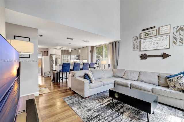 living room featuring visible vents and light wood-style floors