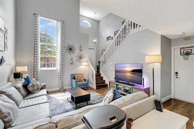 living room with wood finished floors, a healthy amount of sunlight, stairway, and visible vents
