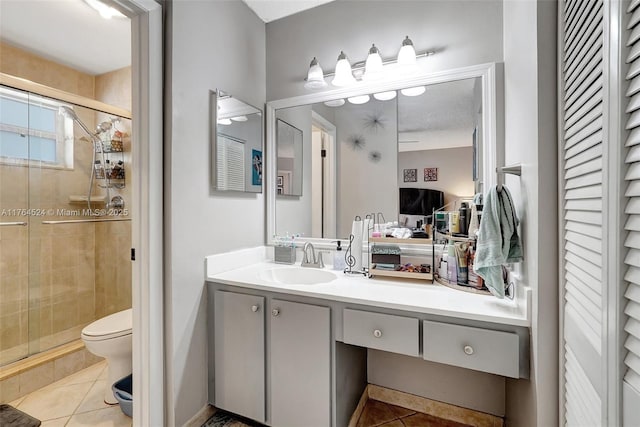 ensuite bathroom with toilet, tile patterned flooring, and a shower stall