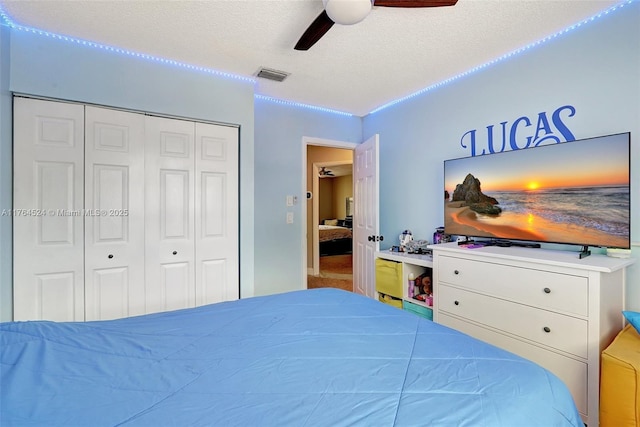 carpeted bedroom featuring visible vents, a closet, ceiling fan, and a textured ceiling
