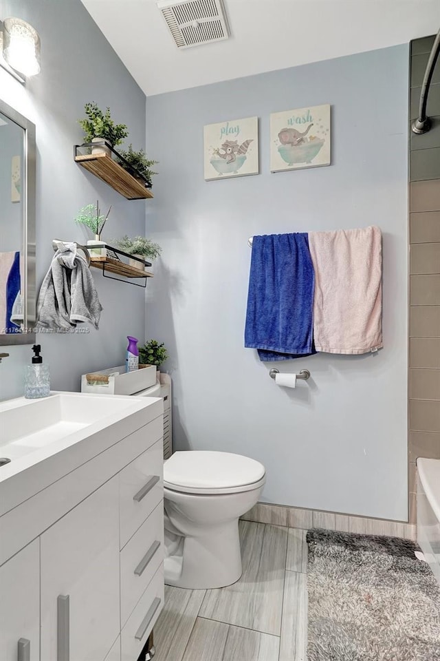 full bathroom featuring visible vents, a bathtub, walk in shower, toilet, and vanity
