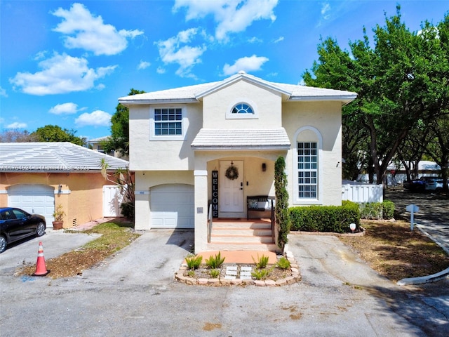 view of front of home with stucco siding, driveway, and an attached garage