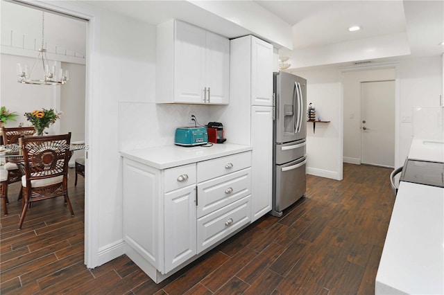 19915 NE 10th Place Way, Miami, FL 33179 - kitchen with stainless steel fridge, dark wood-style flooring, light countertops, white cabinets, and tasteful backsplash