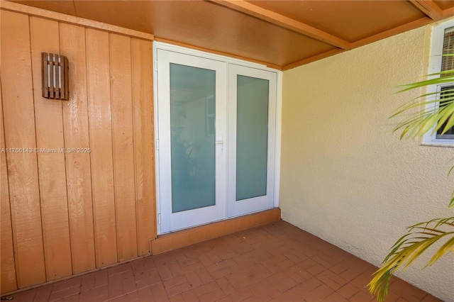 19915 NE 10th Place Way, Miami, FL 33179 - doorway to property featuring board and batten siding, french doors, a patio, and stucco siding