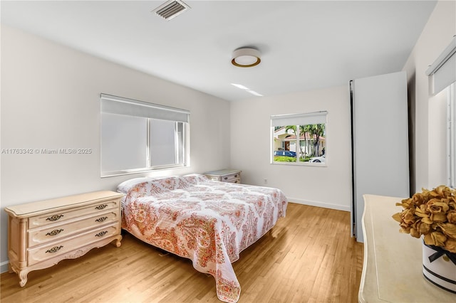 bedroom with visible vents, baseboards, and light wood-type flooring
