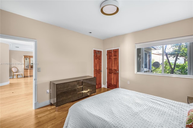 bedroom with baseboards and wood finished floors