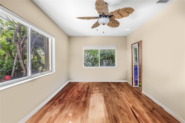 spare room featuring baseboards, visible vents, ceiling fan, and hardwood / wood-style flooring