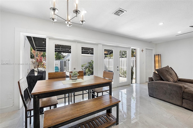 dining room featuring a notable chandelier, recessed lighting, french doors, a textured ceiling, and visible vents