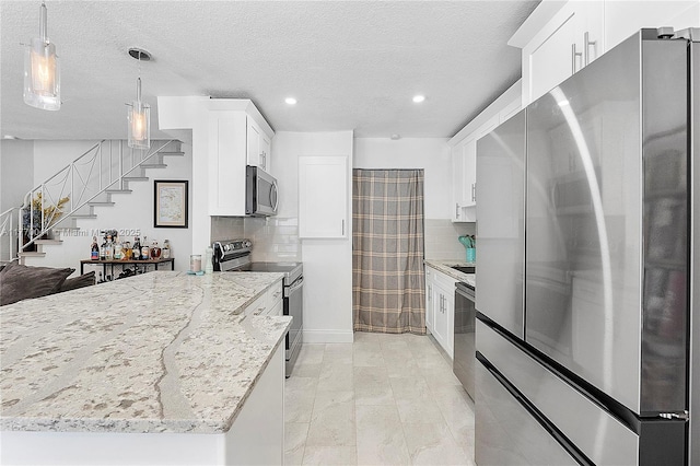 kitchen with light stone countertops, tasteful backsplash, white cabinetry, recessed lighting, and stainless steel appliances