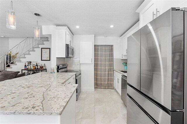8 Hathaway Ln, Wilton Manors, FL 33305 - kitchen with appliances with stainless steel finishes, backsplash, light stone counters, recessed lighting, and white cabinetry